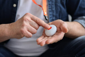 A wireless panic alarm worn around the neck attached to a lanyard for easy activation by anyone who wears it.